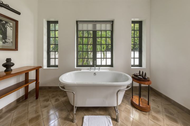 Freestanding bathtub in a bright room with tall windows