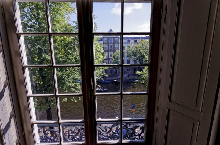 Tall window of a canal house overlooking the canal