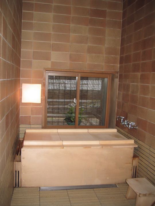 Square hinoki tub in a brick bathroom
