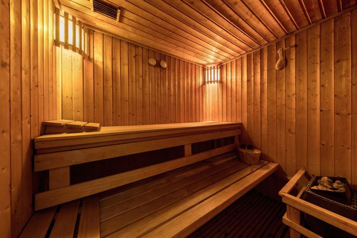 Warm-lit wooden sauna with benches
