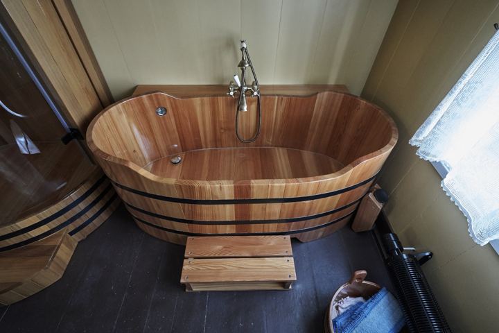 Oval wooden bathtub with tap